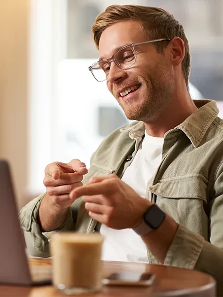 Man smiling and pointing at a computer